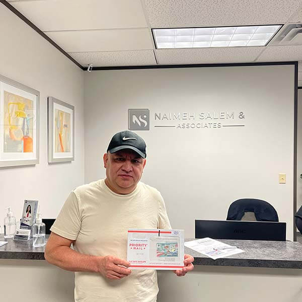 Photo of past client holding immigration papers