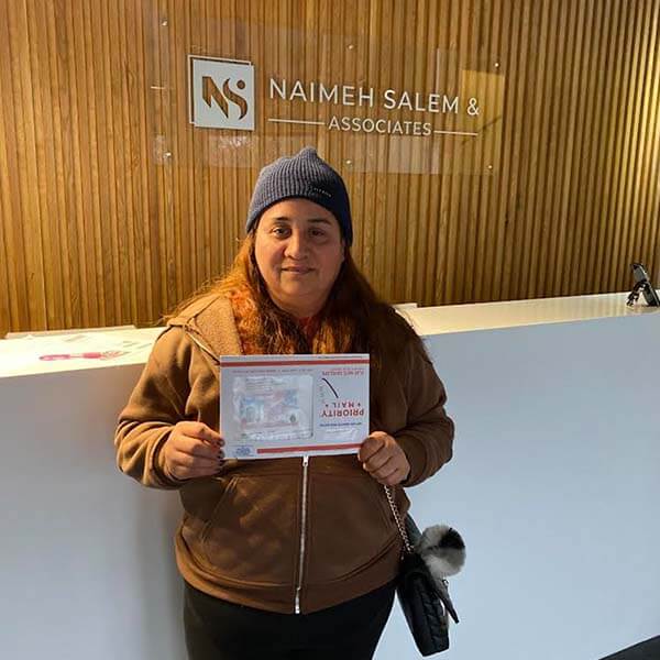 Photo of past client holding immigration papers
